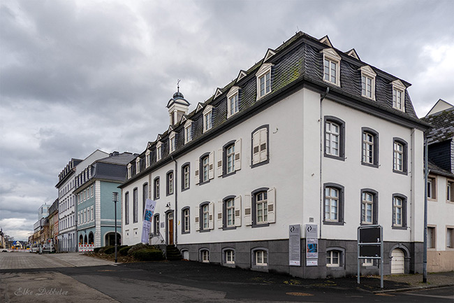 Außenansicht der StadtGalerie Mennonitenkirche in Neuwied, ein weißes historisches Gebäude mit Mansarddach und Sprossenfenstern.